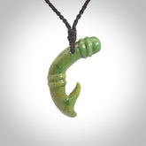 This photo shows a beautiful flower jade bamboo hook suspended from a hand plaited brown cord. The bamboo hook was carved for us by Jen Hung who is a master jade carver from New Zealand.